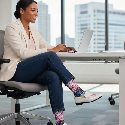 Woman sitting at a desk in an office wearing colorful socks. - Bloom Boldly ready for new beginnings women's socks by Zeblismapo