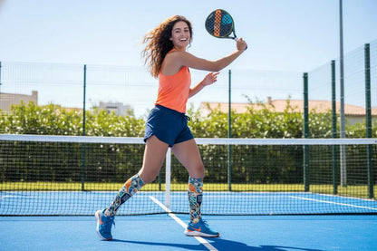 A joyful woman playing paddleball, showcasing her stylish socks and shoes in an energetic mid-action shot 